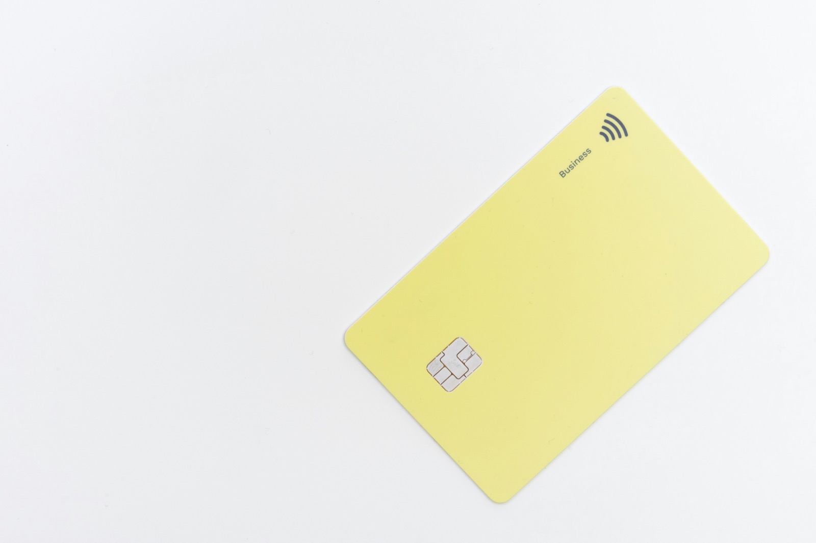 A yellow contactless credit card on a white background